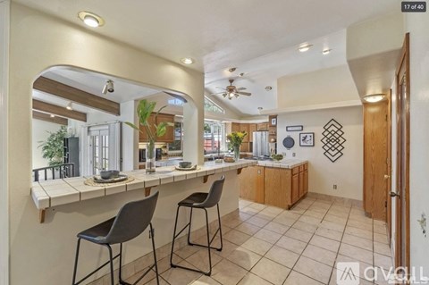 A kitchen with a counter and chairs.