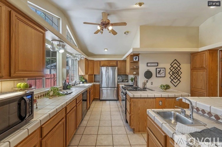 A kitchen with wooden cabinets and a tile floor.