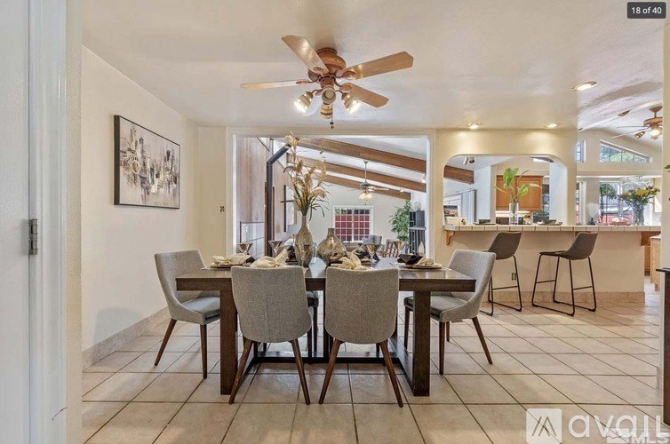 A dining room with a table set for six with chairs around it.