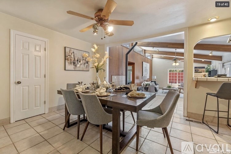 A dining room with a table set for a meal.