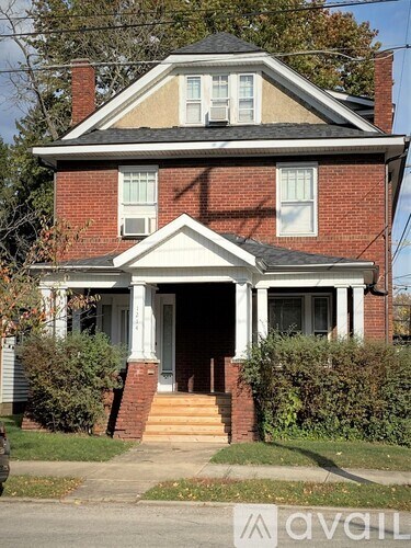 A red brick house with a white door and windows.