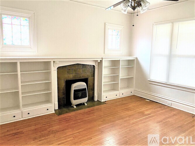 A room with a fireplace and a fan on the ceiling.