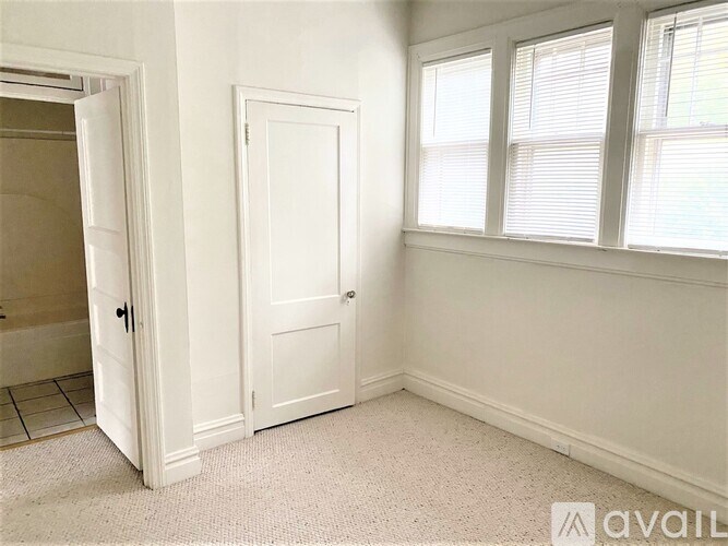 A room with a door and a window with blinds.