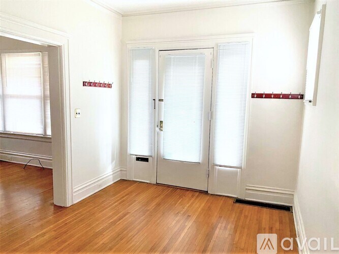 A room with a white door and a window with blinds.