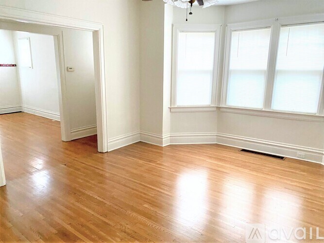 A room with wooden floors and a ceiling fan.