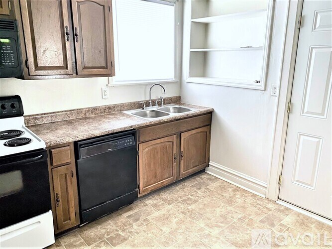 A kitchen with a black oven and a white fridge.