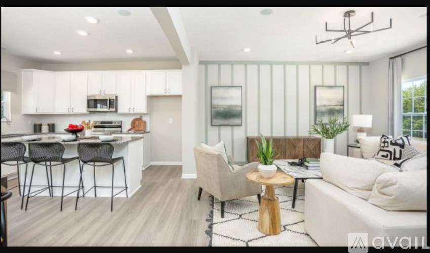 A modern living room with a dining area and kitchen in the background.