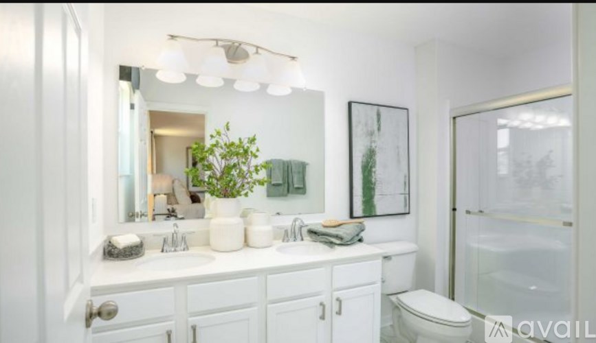 A bathroom with a white toilet, sink, and mirror.