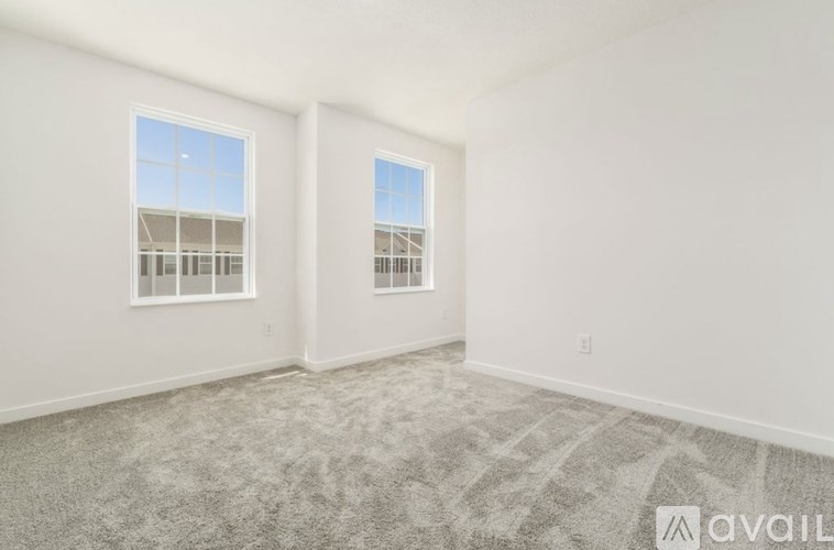 A room with two windows and carpeted floor.