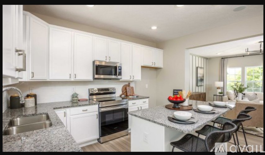 A kitchen with white cabinets and a granite countertop.