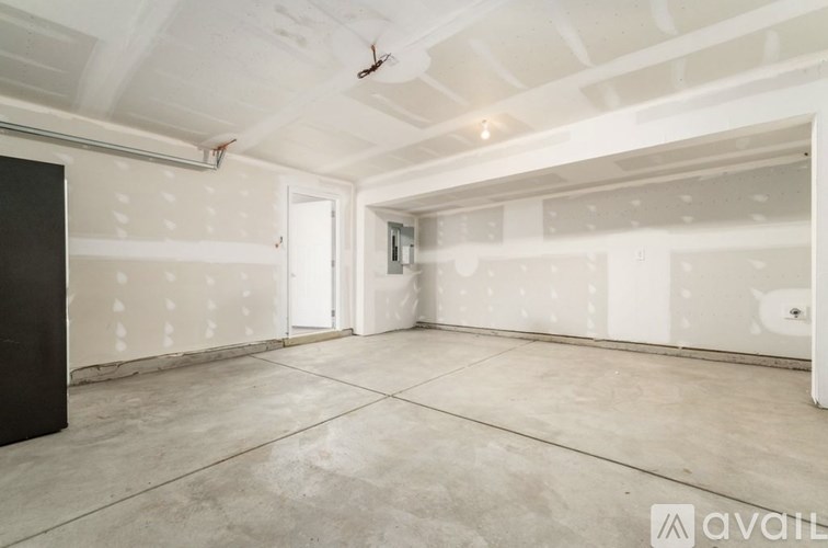A room with white walls and a concrete floor is available for rent.