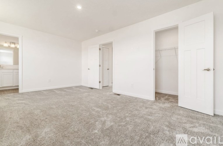 A spacious room with carpeted floor and white walls.