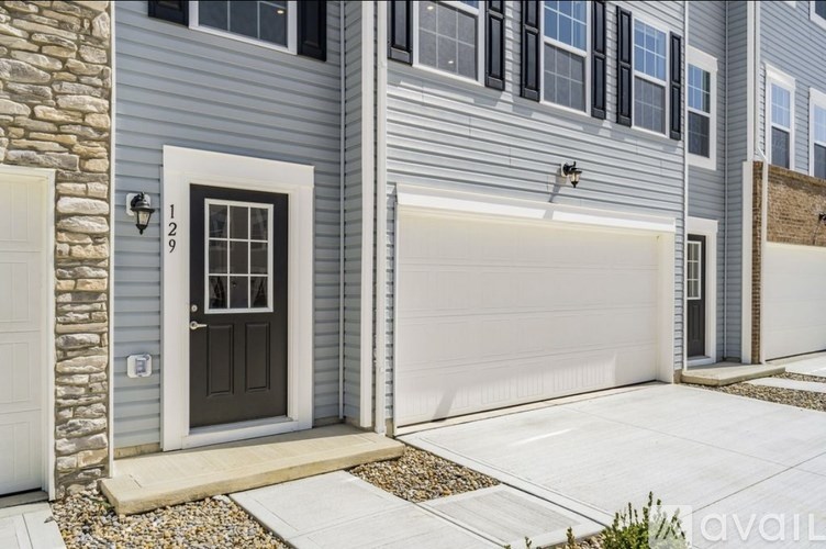 A modern house with a grey exterior and a black front door.