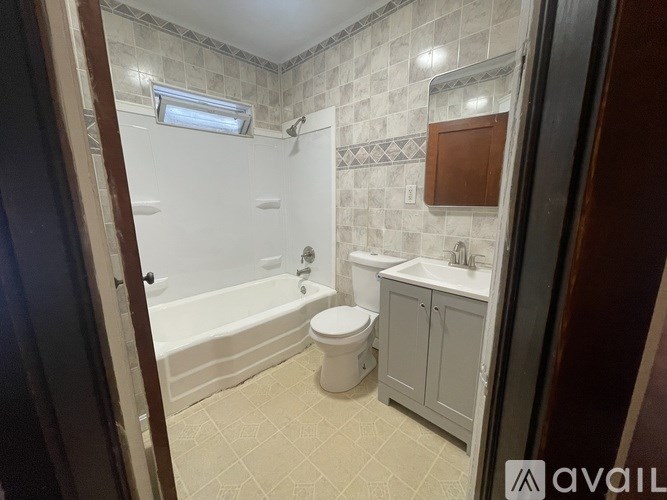A bathroom with a white toilet, a bathtub, and a sink.