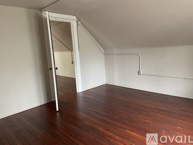 A room with a wooden floor and a white door.