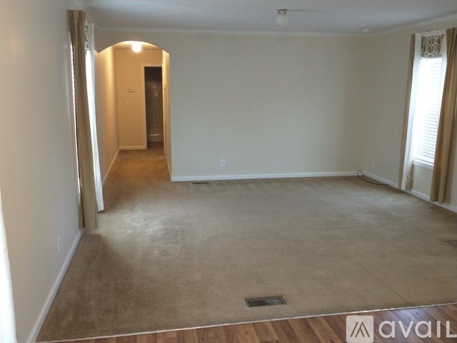 A room with a carpeted floor and a doorway leading to another room.