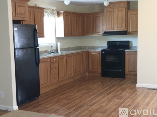 A kitchen with wooden cabinets and black appliances.