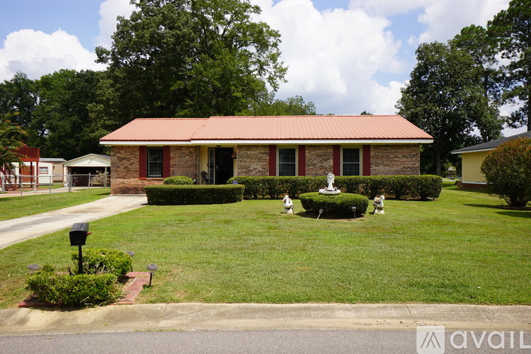 A house with a red roof and a green lawn.