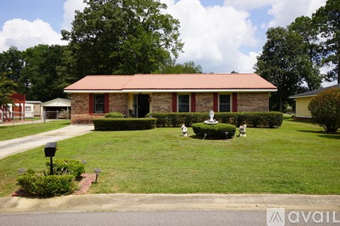 A house with a red roof and a green lawn.