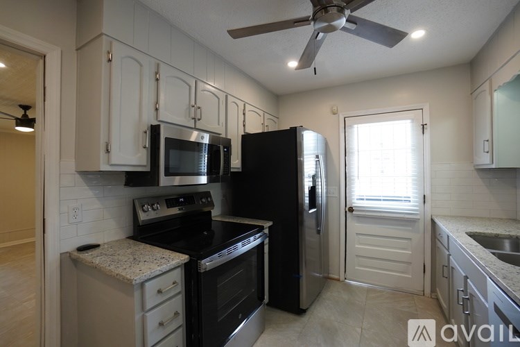 A kitchen with black appliances and white cabinets.