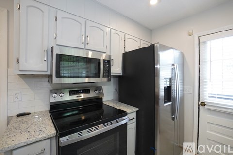 A kitchen with a black refrigerator and stove.