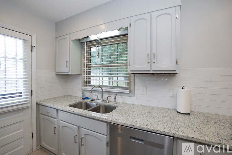 A kitchen with white cabinets and a granite countertop.