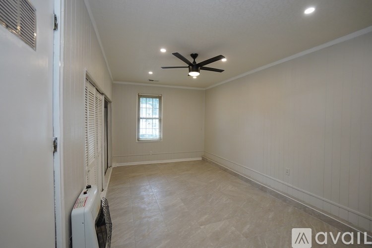 A room with a ceiling fan and a window.