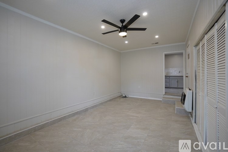 A room with a ceiling fan and a wall-mounted air conditioner unit.