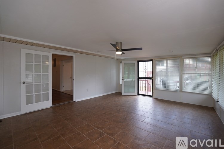 A room with brown tiles on the floor and a ceiling fan.