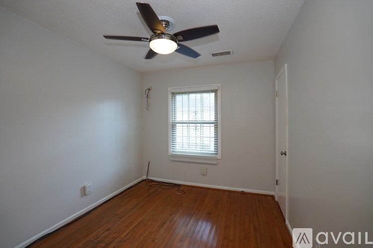 A room with a ceiling fan and a window with blinds.