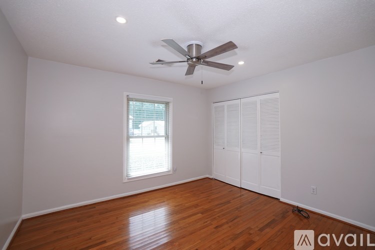 A room with a ceiling fan and wooden flooring.