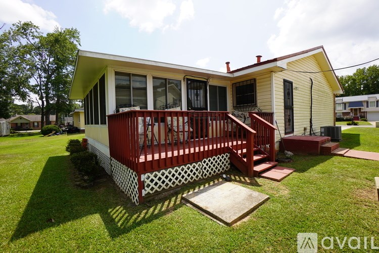 A yellow house with a red porch and a white picket fence.