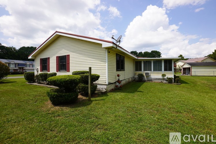 A house with a red roof and a green lawn.