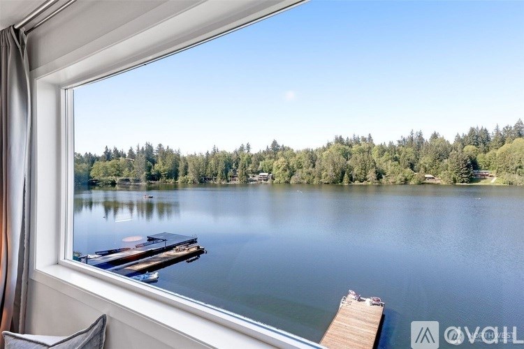 A serene lake view with boats docked at the pier.