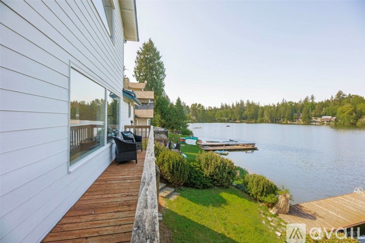 A house with a wooden deck overlooking a lake.