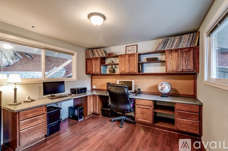 A home office with a desk, chair, and shelves.