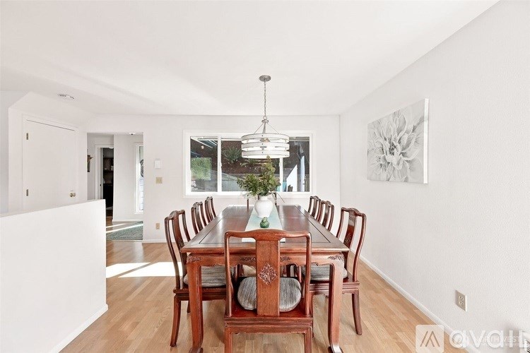 A dining room with a wooden table and chairs.