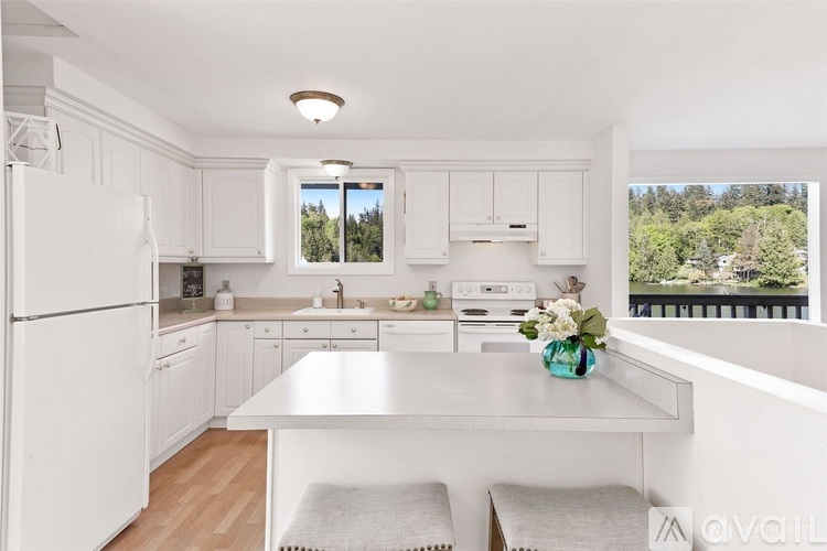 A kitchen with white cabinets and a large island.