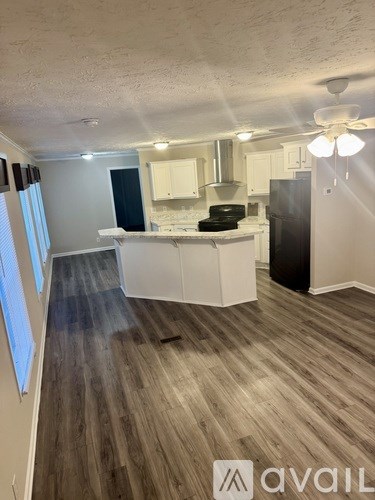 A kitchen with a refrigerator, stove, and cabinets.