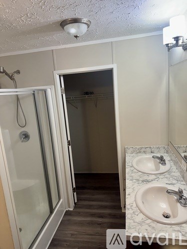 A bathroom with a marble counter top and a walk in shower.