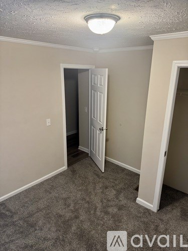 A room with a carpeted floor and a white door.