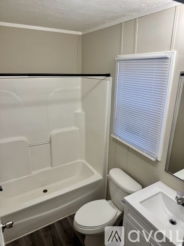 A white toilet sits next to a bathtub in a bathroom.