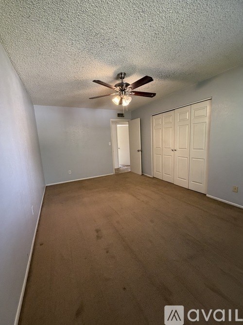 A hallway with a closed door and a mirror on the wall.