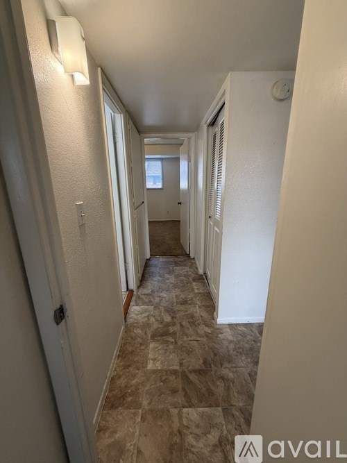 A long hallway with tiled floors and white walls.