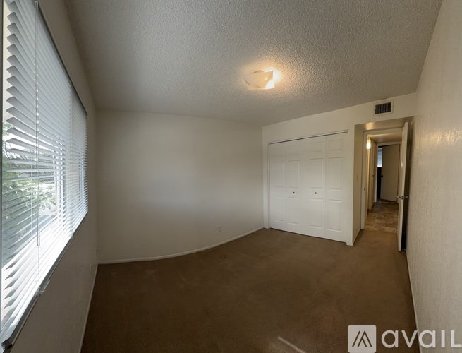 A room with a white door and a window with blinds.