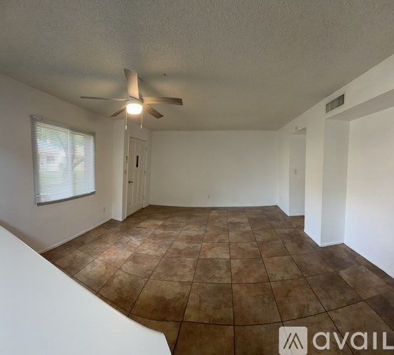 A room with a tiled floor and a ceiling fan.