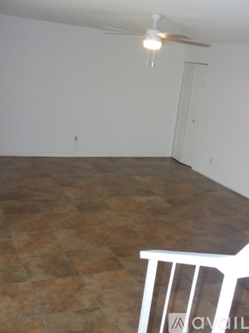 A room with a tile floor and a ceiling fan.