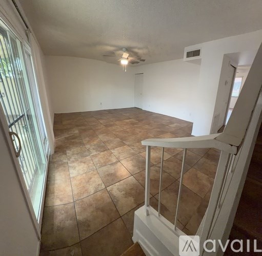 A tree-lined street with houses on either side.