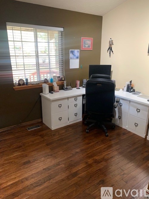 A room with a desk, chair, and a computer monitor.