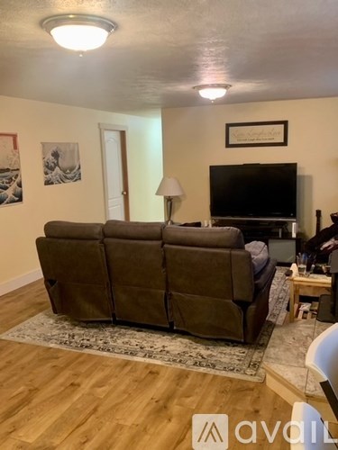 A living room with a brown couch and a flat screen TV.